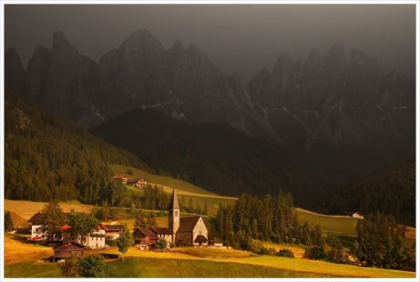 Bouřková atmosféra a posledním sluncem nasvícený kostel v údolí Val di Funs- fotografický workshop Rozkvetlé letní Dolomity