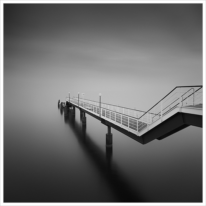 Černobílá minimalistická fotografie kovového mola na pobřeží baltského moře na ostrově Usedom na severu Německa - Fotografický workshop Tajemné baltské pobřeží Usedom